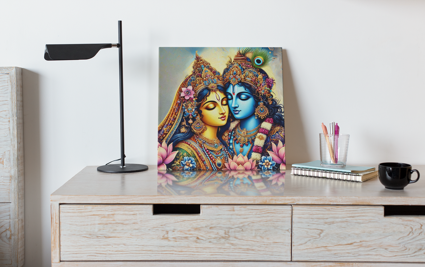 Radha Krishna canvas wall art depicting colorful traditional Indian artwork displayed on wooden desk