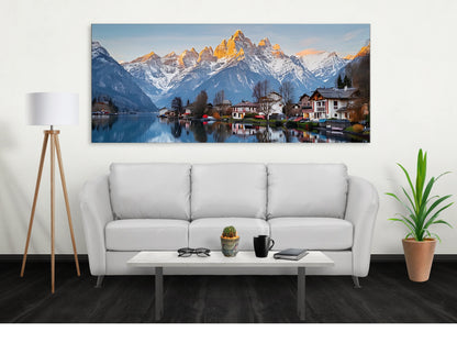 Mountain lake canvas wall art by lilmonal featuring serene lakeside village and snow-capped mountains above a modern white sofa